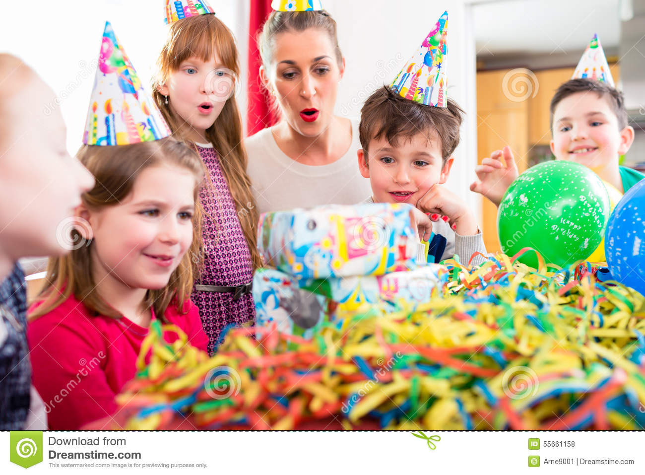 Child Birthday Gift Baskets
 Child Unwrapping Birthday Gift With Friends Stock